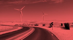 A road with wind turbines in the background.