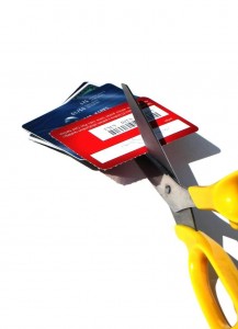 A pair of scissors cutting through credit cards.